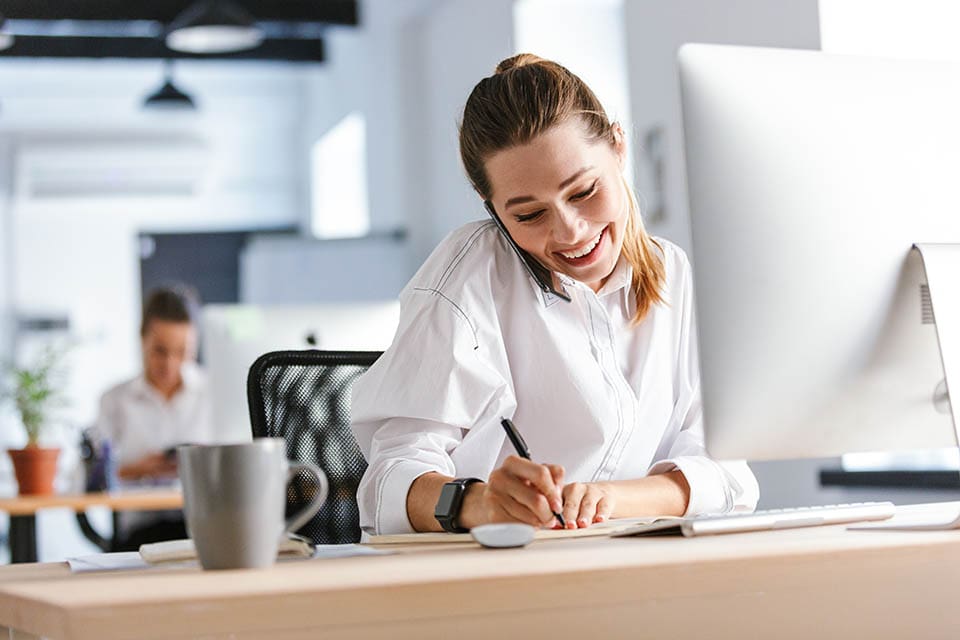 Side view of businesswoman typing on keyboard at desk in call center